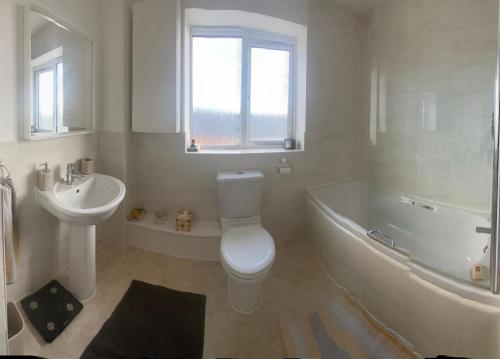 a bathroom with a toilet and a tub and a sink at Bodmin Rest 4 U in Bodmin