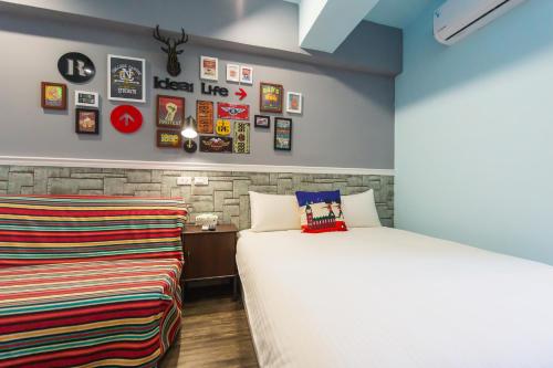 a bedroom with two beds and pictures on the wall at Kaohsiung I Hi Hotel in Kaohsiung