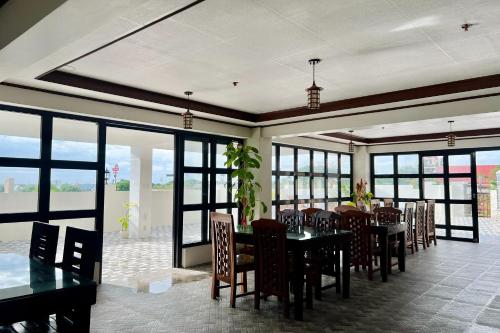 MC's L Transient House في Bantay: غرفة طعام مع طاولات وكراسي ونوافذ