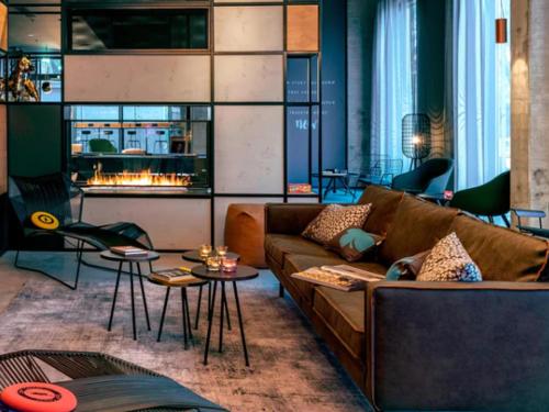 a living room with a couch and a fireplace at Moxy Milan Linate Airport in Segrate