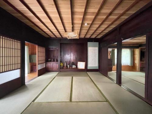 a large room with a wooden ceiling and a room at Yakushima Umigame house　屋久島 海がめの里 蘭亭 in Yakushima