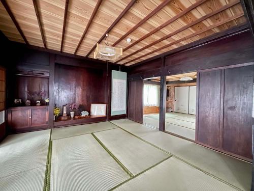 a large room with a wooden ceiling and a hallway at Yakushima Umigame house　屋久島 海がめの里 蘭亭 in Yakushima