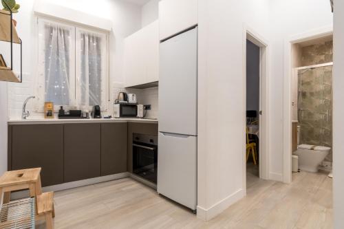 eine Küche mit einem großen weißen Kühlschrank in einem Zimmer in der Unterkunft 2 habitaciones 2 baños- Moderno y Acogedor - Imperial in Madrid