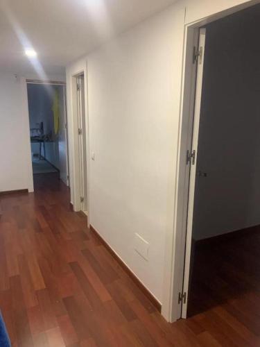 una stanza vuota con pareti bianche e pavimenti in legno di Tokyo Rooms "El Cabo" Habitación doble con baño privado a Almería