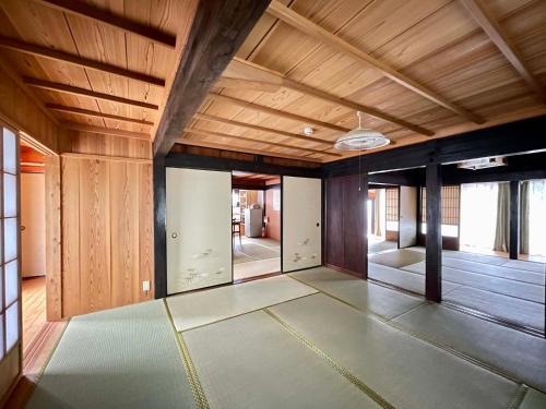 an empty room with a wooden ceiling and a floor at Yakushima Umigame house　屋久島 海がめの里 蘭亭 in Yakushima