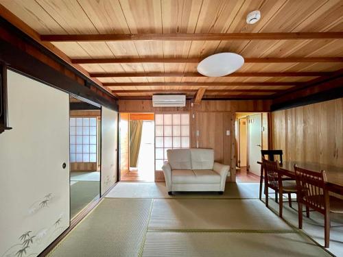 ein Wohnzimmer mit einem Sofa und einem Tisch in der Unterkunft Yakushima Umigame house　屋久島 海がめの里 蘭亭 in Yakushima