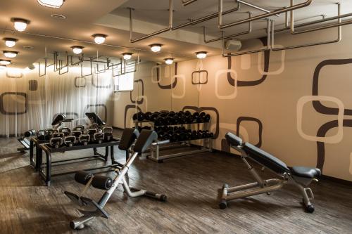 a gym with treadmills and chairs in a room at THOMSN Central Hotel & Appartements in Saalbach Hinterglemm
