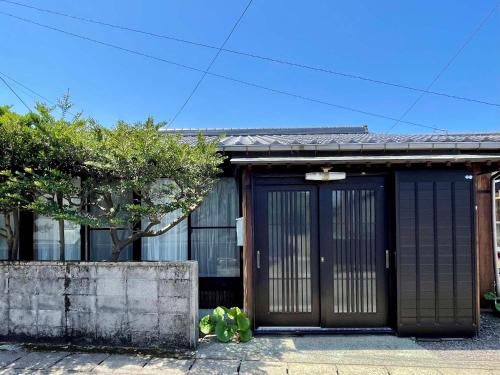 une maison avec deux portes dans une rue dans l'établissement Yakushima Umigame house　屋久島 海がめの里 蘭亭, à Yakushima