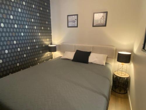 a bedroom with a large bed with two lamps at Marianne 3 in Bergerac