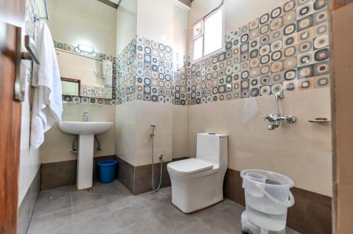 a bathroom with a toilet and a sink at Royal Inn in Jammu