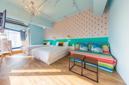 a bedroom with two beds and a couch in it at Kaohsiung I Hi Hotel in Kaohsiung