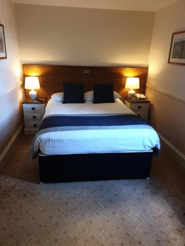 a hotel room with a large bed with two lamps at The Pegwell Bay Hotel in Ramsgate
