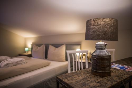 a bedroom with a bed and a table with a lamp at THOMSN Central Hotel & Appartements in Saalbach Hinterglemm