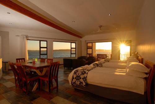 a hotel room with two beds and a table at The Cormorant House in Lüderitz