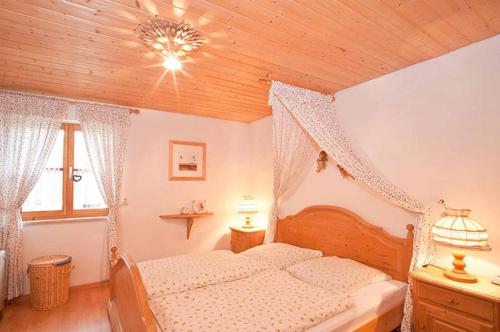 una camera con letto e soffitto in legno di Feriendorf Reichenbach - Biberweg 3 a Nesselwang