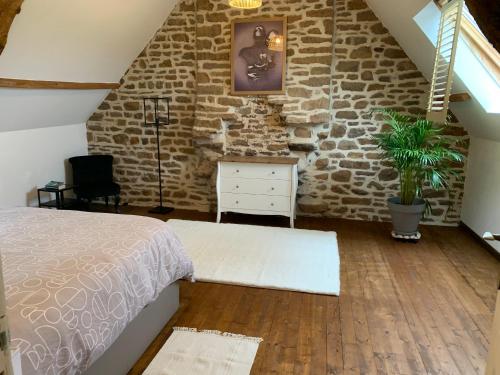 a bedroom with a bed and a stone wall at Gîte la belle etoile in Ver