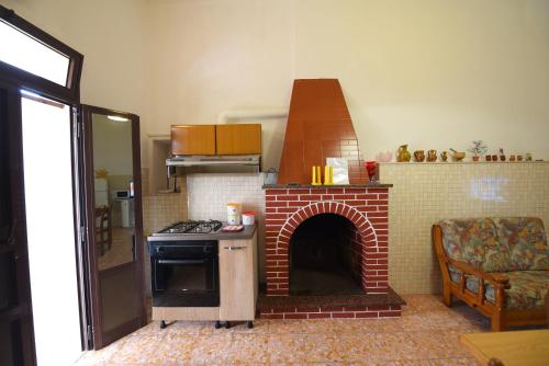 a kitchen with a brick fireplace with a stove at Casa in campagna in Cisternino