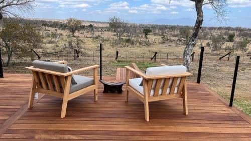 two chairs sitting on top of a wooden deck at Tomo Safari Lodge in Hoedspruit