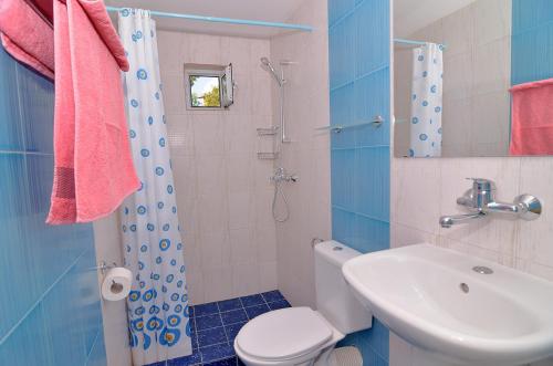 a bathroom with a toilet and a sink and a shower at Royal Villas in Bryastovets