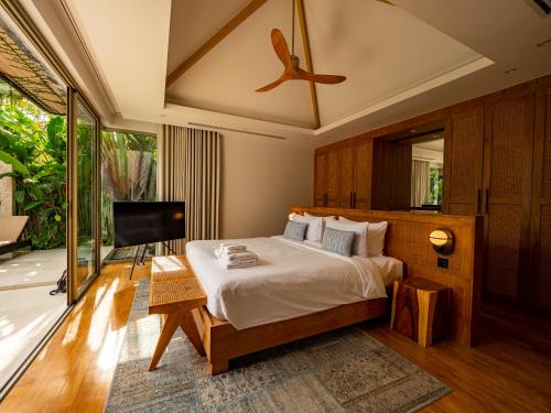 a bedroom with a large bed and a television at Exclusive Villa Botanica in Bang Tao Beach