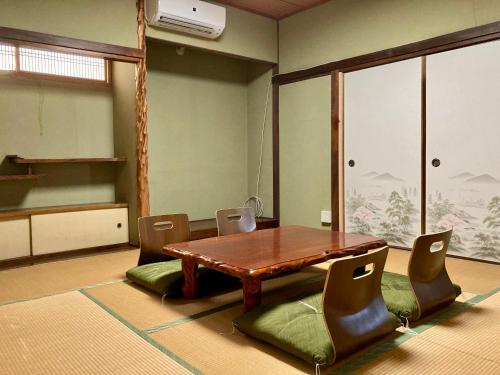 ein Esszimmer mit einem Holztisch und Stühlen in der Unterkunft Nostime lodge 女性限定 female only in Kitakyūshū