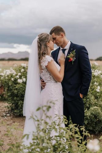 a bride and groom kissing in a field of flowers at Out Of Nature Country Lodge in Windhoek