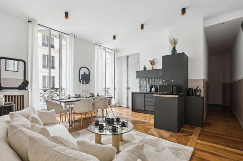 un salon avec un canapé et une table dans l'établissement Champs Elysées luxury 3 bed room, à Paris