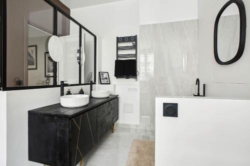 une salle de bain avec deux lavabos et un grand miroir dans l'établissement Champs Elysées luxury 3 bed room, à Paris