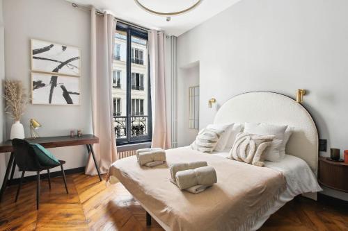 une chambre avec un lit blanc avec deux oreillers dessus dans l'établissement Champs Elysées luxury 3 bed room, à Paris