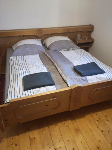 un letto in legno con due cuscini sopra di Ferienwohnung Niklas a Saulgrub
