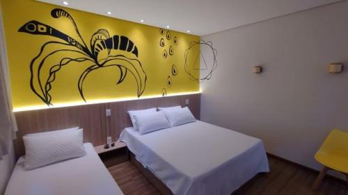 a bedroom with two beds and a painting on the wall at Pousada Boutique Raio de Luz in Ouro Preto