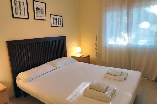 um quarto com uma cama grande e toalhas em Fragata em Estepona