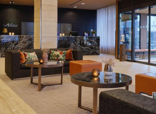 a lobby with couches and tables in a building at Adina Apartment Hotel Hamburg Michel in Hamburg