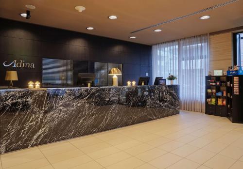 un vestíbulo con un mostrador de mármol en un hotel en Adina Apartment Hotel Hamburg Michel, en Hamburgo