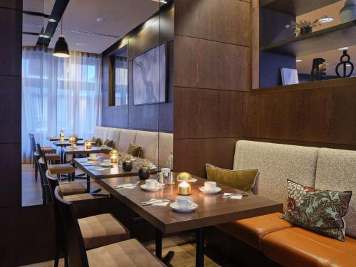 a row of tables in a restaurant with candles on them at Adina Apartment Hotel Hamburg Michel in Hamburg