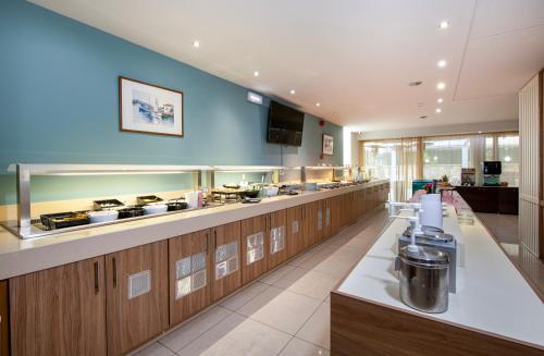 a large kitchen with wooden cabinets and a counter top at Atrion Resort Hotel in Agia Marina Nea Kydonias