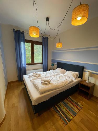 a bedroom with a bed and two lamps and a window at Klimatyzowany apartament z basenem i garażem Willa 4 Pory Roku in Jastrzębia Góra