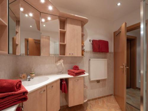 łazienka z umywalką i dużym lustrem w obiekcie Appartement Pöll Kathrin w mieście Westendorf