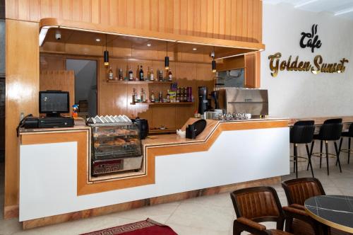 a fast food restaurant with a counter with chairs at Hotel Golden Sunset Dakhla in Dakhla