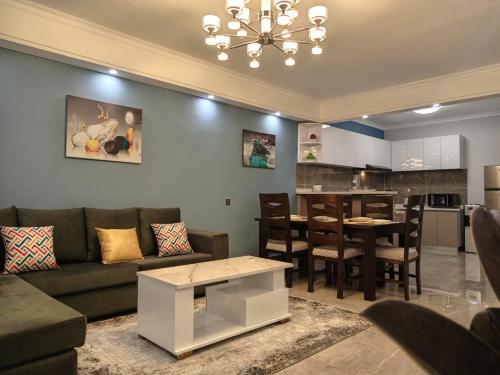 a living room with a couch and a table and a kitchen at New 2 & 3 bedroom Apartment in Kilimani Nairobi with rooftop pool in Nairobi
