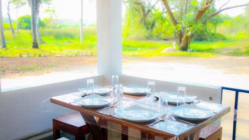 Bird View Resort Anawilundawa : طاولة عليها صحون واكواب للنبيذ