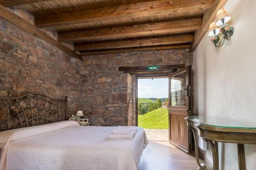 a bedroom with a bed in a stone wall at Leyendas del Miera in Liérganes