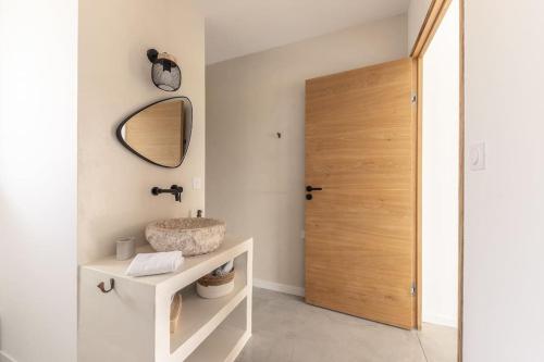 ein Badezimmer mit einem Waschbecken, einem Spiegel und einer Tür in der Unterkunft VILLA KASBAR avec spa privé 4 étoiles in Tizac-de-Curton
