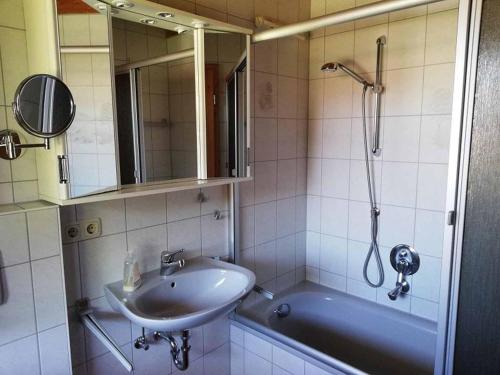 uma casa de banho com um lavatório, uma banheira e um chuveiro em Feriendorf Reichenbach - Biberweg 12 em Nesselwang
