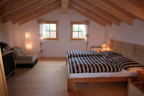 um quarto com uma cama grande e 2 cadeiras em Feriendorf Reichenbach - Biberweg 12 em Nesselwang