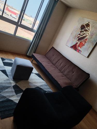 Sofá en habitación con ventana grande en Apartamento en chiclayo Perú, en Chiclayo