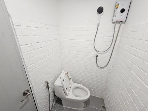 a bathroom with a toilet and a shower at The White Den Sukhumvit 44 in Bangkok