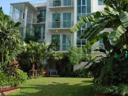 a large apartment building with a lawn in front of it at P.K. Garden Home in Bangkok
