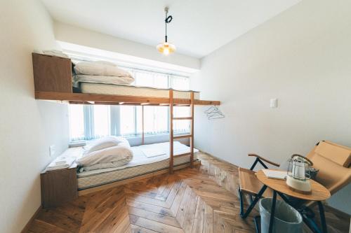 a room with two bunk beds and a desk at Charlie's Bed in Wakayama
