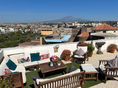 a balcony with a couch and chairs and a table at Residenza Parco Gioeni in Catania